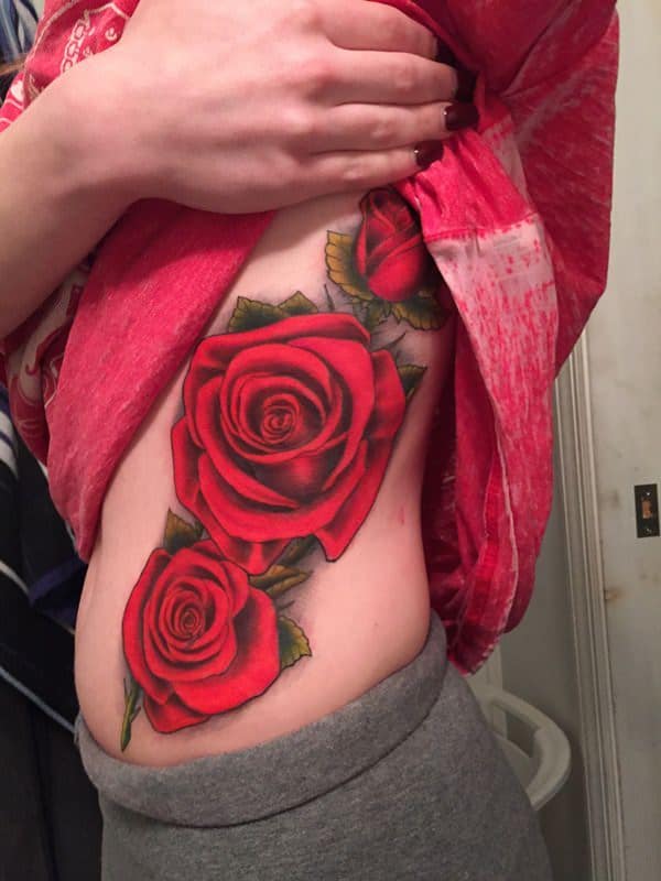 Fine line rose tattoo on the rib