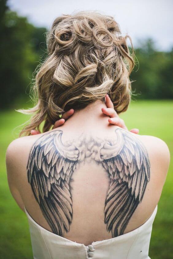 Fine line wings tattoo on the upper back